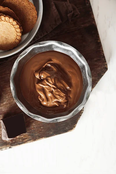 Gesmolten chocolade in kom, op houten achtergrond — Stockfoto