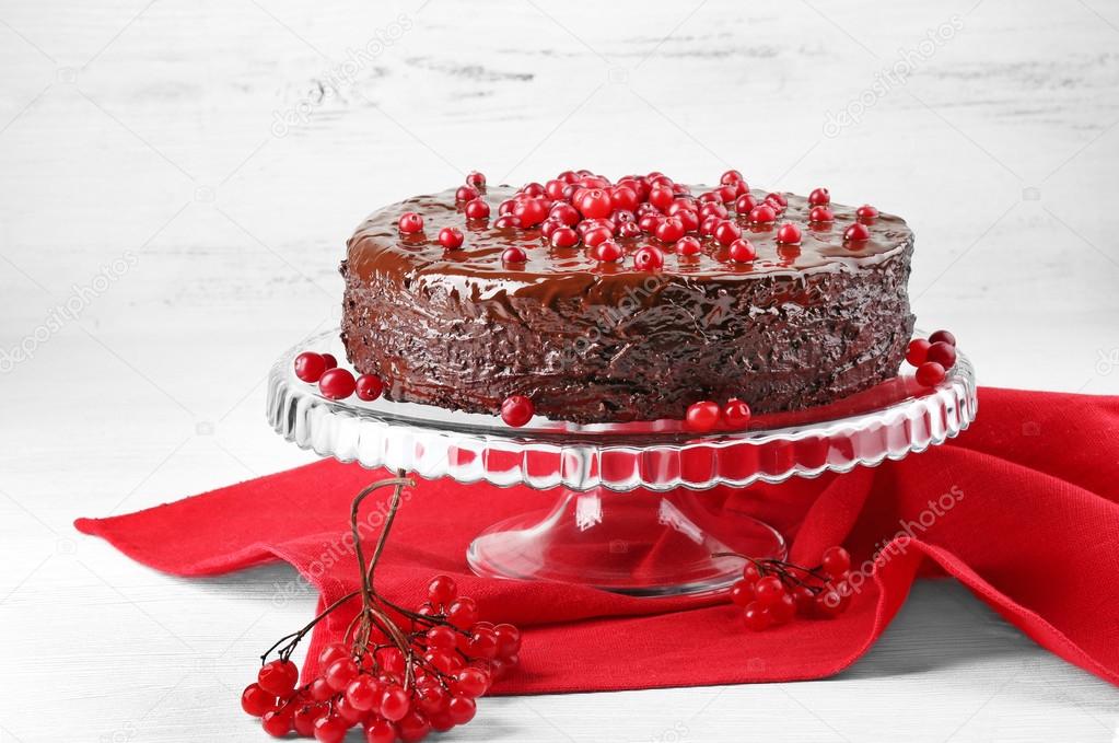 Chocolate cake with cranberries on wooden background