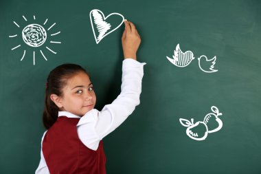 Güzel küçük kız sınıfta blackboard çizim