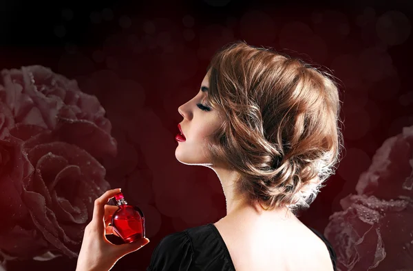 Beautiful young woman with perfume bottle — Stock Photo, Image