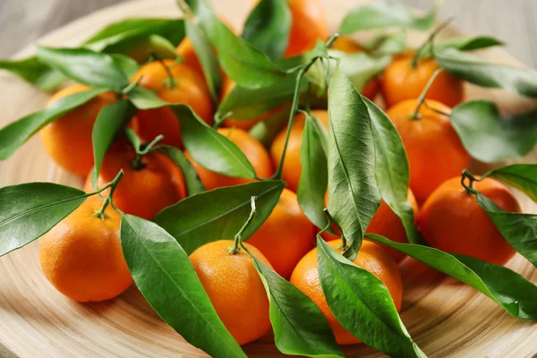 Fresh tangerines with leaves on wooden table, closeup — Stock Photo, Image