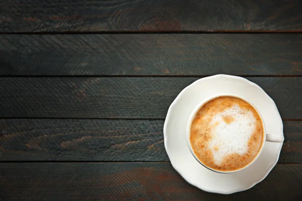 Coupe de cappuccino chaud avec mousse sur une table en bois noir — Photo