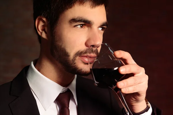 Человек, нюхающий красное вино в стакане — стоковое фото