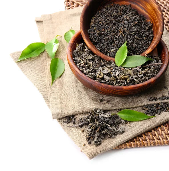 Trockener Tee mit grünen Blättern in Holzgeschirr, isoliert auf weißem — Stockfoto