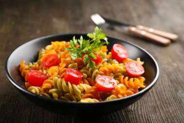 Lezzetli makarna yemek hizmet ahşap masa üzerinde siyah kase