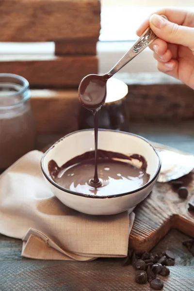 Растаянный шоколад в стеклянной чаше, на деревянном фоне — стоковое фото