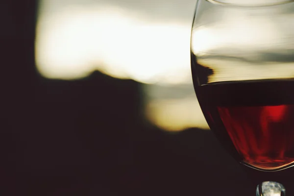 Glas Rotwein auf verschwommenem Hintergrund — Stockfoto