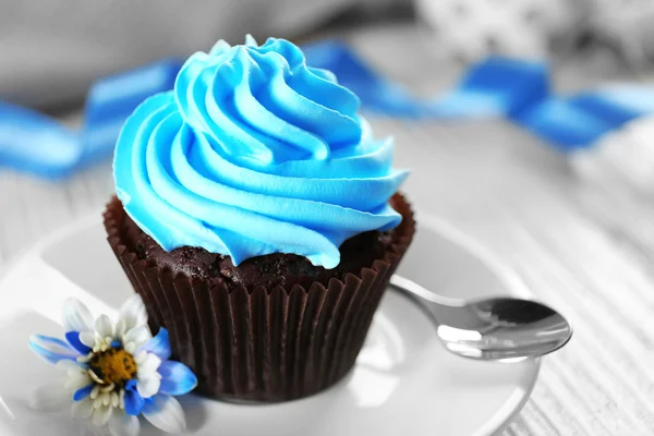 美味的巧克力蛋糕，奶油蓝色装饰木制的桌子上关闭 — 图库照片