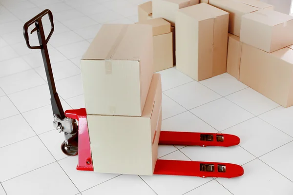 Fork pallet truck with stack of cardboard boxes — Stock Photo, Image