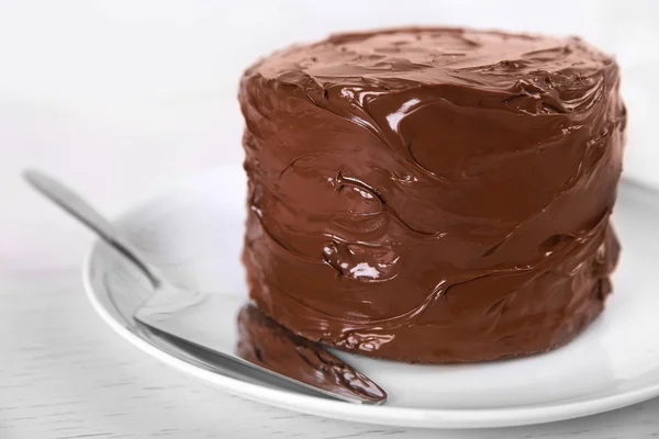 Gâteau au chocolat sur une assiette avec lame sur fond clair, gros plan — Photo