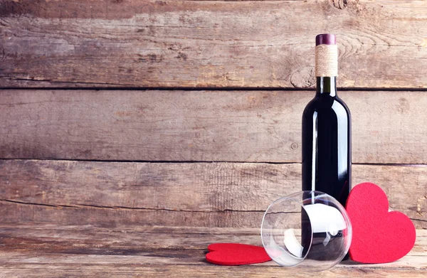 Red hearts with wine bottle and glass — Stock Photo, Image