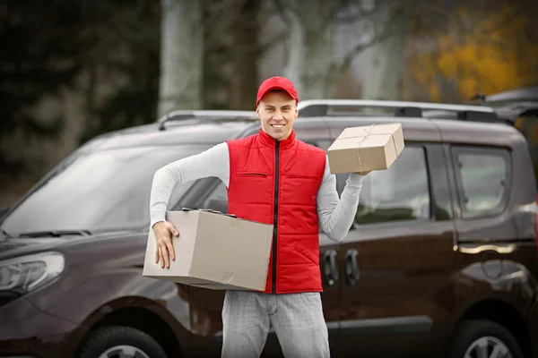 Jovem homem bonito entrega — Fotografia de Stock