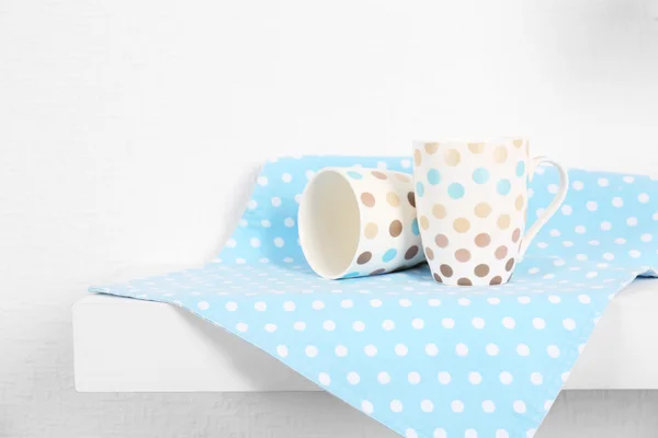 Set of cups with napkin on shelf — Stock Photo, Image