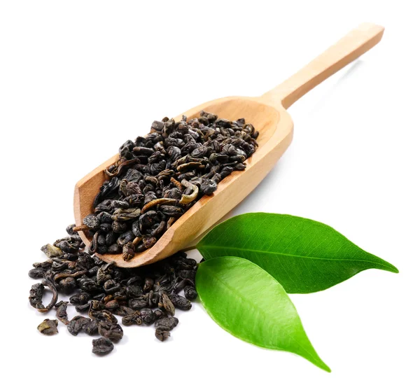 Suchej herbaty zielone liście w drewnianą łyżką, na białym tle — Zdjęcie stockowe