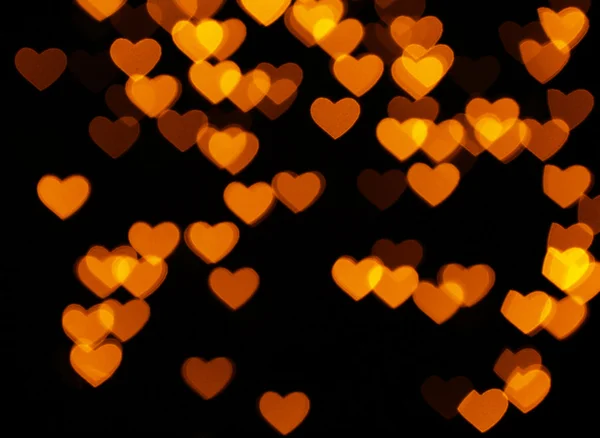 Viele orangefarbene Herzen auf schwarz — Stockfoto
