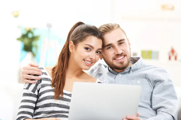 Pareja feliz y trabajando en un ordenador portátil —  Fotos de Stock