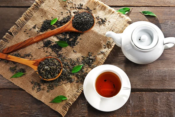 Stillleben mit granuliertem Tee und grünen Blättern auf Holztisch, Draufsicht — Stockfoto