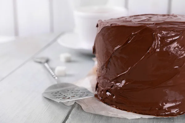 Pastel de chocolate con hoja sobre un fondo de mesa de madera — Foto de Stock