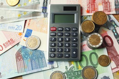 Para kavramı. Gri hesaplayıcıyla banknot ve madeni paralar, yakın çekim