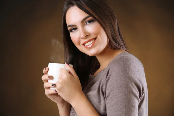 Portret van lachende mooie vrouw met kop koffie — Stockfoto