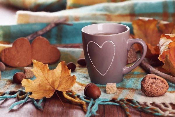 Tasse Tee mit Herbstdekor auf Holztisch. — Stockfoto