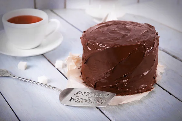 一杯の紅茶と木製のテーブル背景にブレードとチョコレート ケーキ — ストック写真