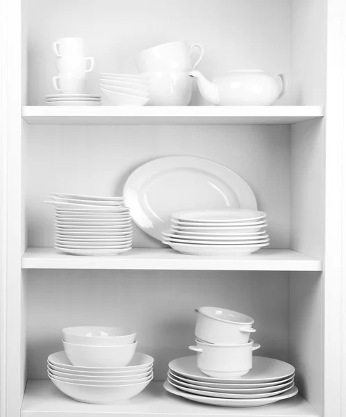 Dishes in cupboard in kitchen — Stock Photo, Image