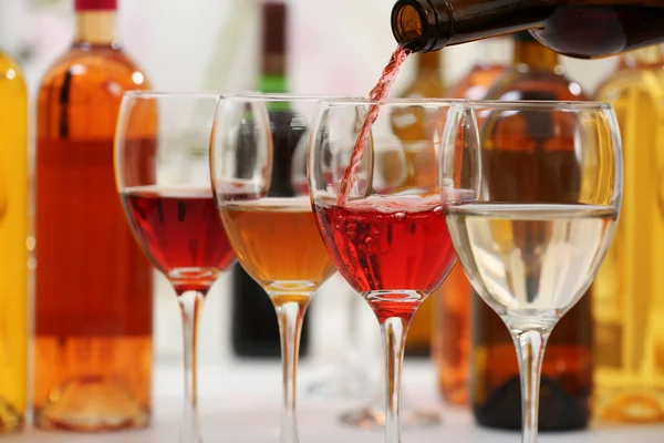 Red wine pouring into glasses, closeup — Stock Photo, Image