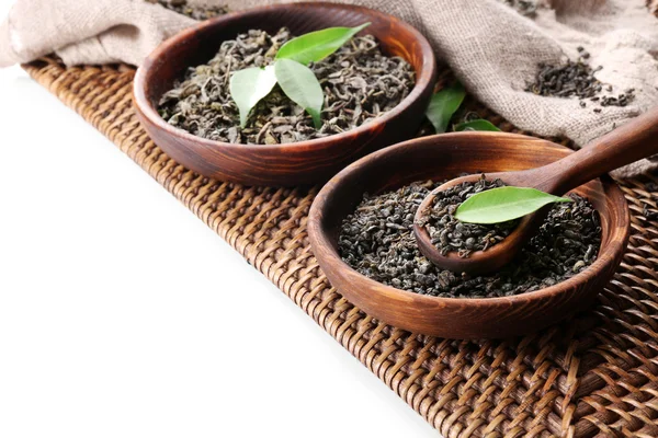 Tè secco con foglie verdi in utensile di legno, isolato su bianco — Foto Stock