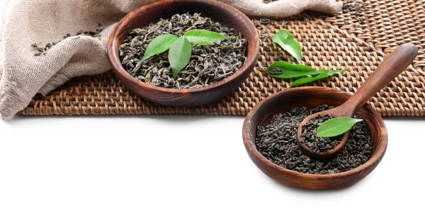 Té seco con hojas verdes en utensilio de madera, aislado en blanco —  Fotos de Stock