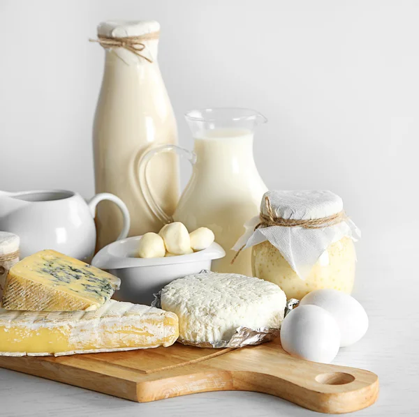 Taze süt ürünler ve beyaz arka plan üzerinde ahşap tablo ayarlama — Stok fotoğraf