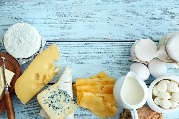 Çerçeve mavi ahşap masa üzerinde taze süt ürünleri — Stok fotoğraf