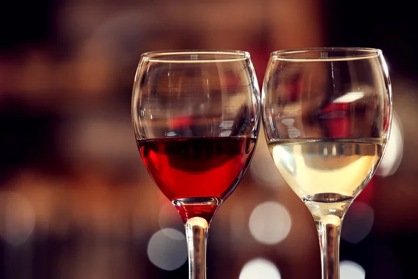 Vasos de vino tinto y blanco sobre fondo borroso — Foto de Stock