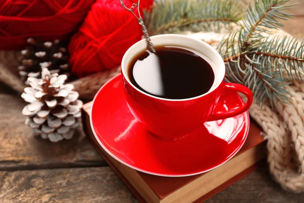 Чашка горячего напитка с вязаным теплым зимним шарфом на старом деревянном столе — стоковое фото