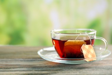 Siyah çay yeşil arka plan bulanık, cam bardakta çantada ile yakın çekim