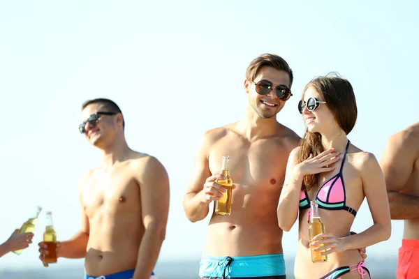 Happy friends drinking beer at beach — Stock Photo, Image