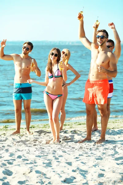 Happy friends drinking beer at beach — Stock Photo, Image