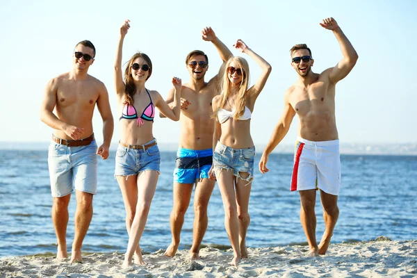 Glückliche Freunde laufen am Strand — Stockfoto