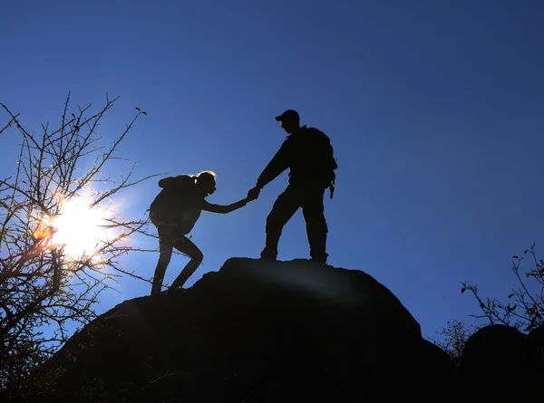 Homme et femme escaladant la montagne — Photo