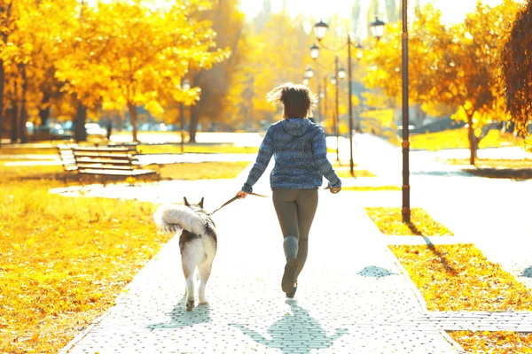 Женщина бегает со своей собакой в парке — стоковое фото