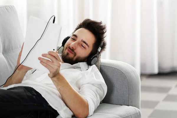 Jongeman luistert muziek met koptelefoon — Stockfoto