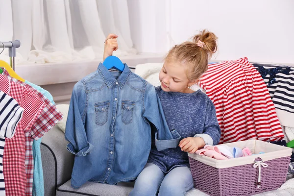 Menina tentando em roupas — Fotografia de Stock