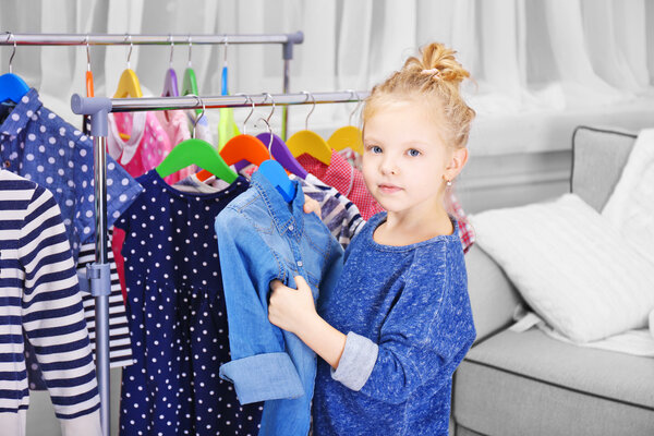 Маленькая девочка примеряет футболку
