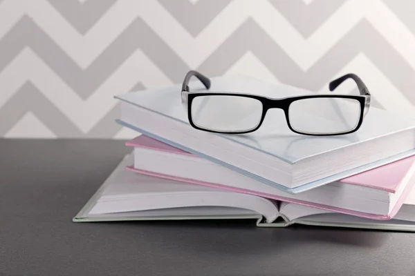 Boeken en brillen op grijze tafel — Stockfoto