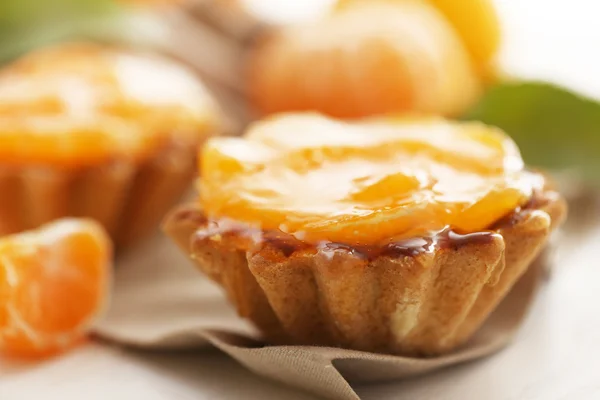 Pasteles dulces con mandarinas en la mesa — Foto de Stock