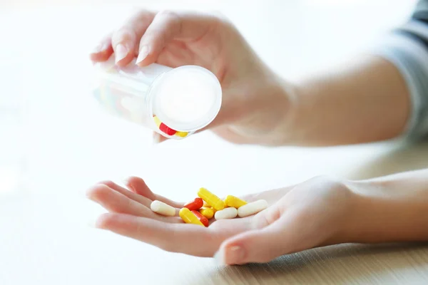Woman spills yellow medical capsules — Stock Photo, Image