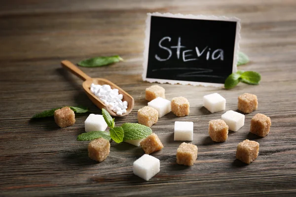 Слово STEVIA написано на черной доске и сахаре — стоковое фото