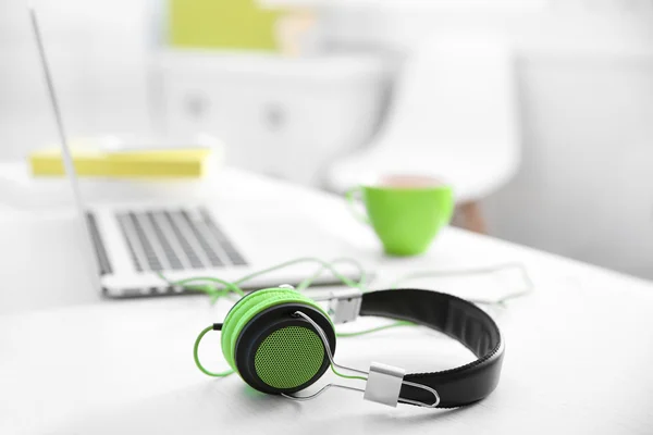 Fones de ouvido e laptop na mesa — Fotografia de Stock