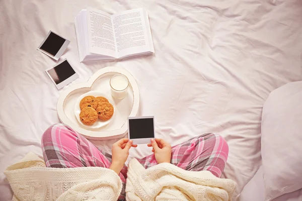 Frau im Pyjama schaut sich Fotos an — Stockfoto