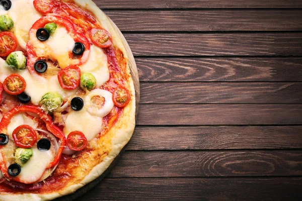 Ízletes pizza sajttal és zöldséggel fából készült háttér — Stock Fotó